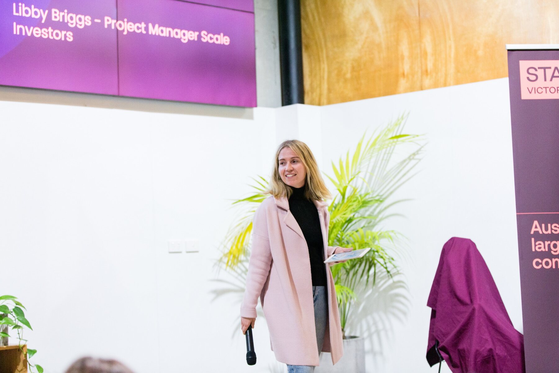 Libby Briggs facilitating an event on stage